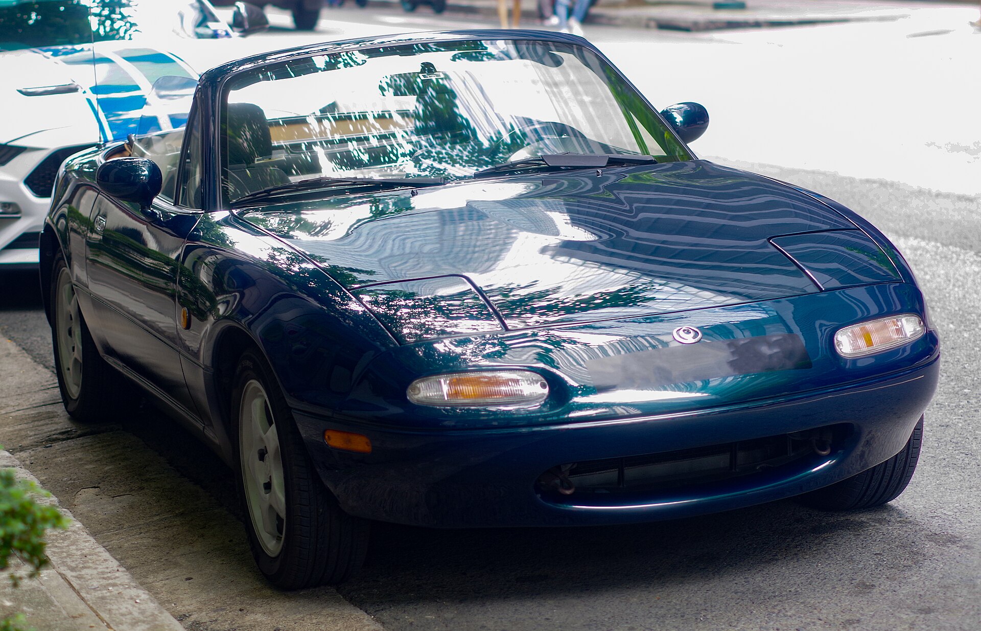 Mazda MX-5 NA in Montego Blue Mica mit offenem Verdeck, Frontansicht, Baujahr 1997